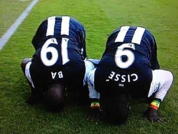Demba Ba and Papiss Cisse prostrate themselves.